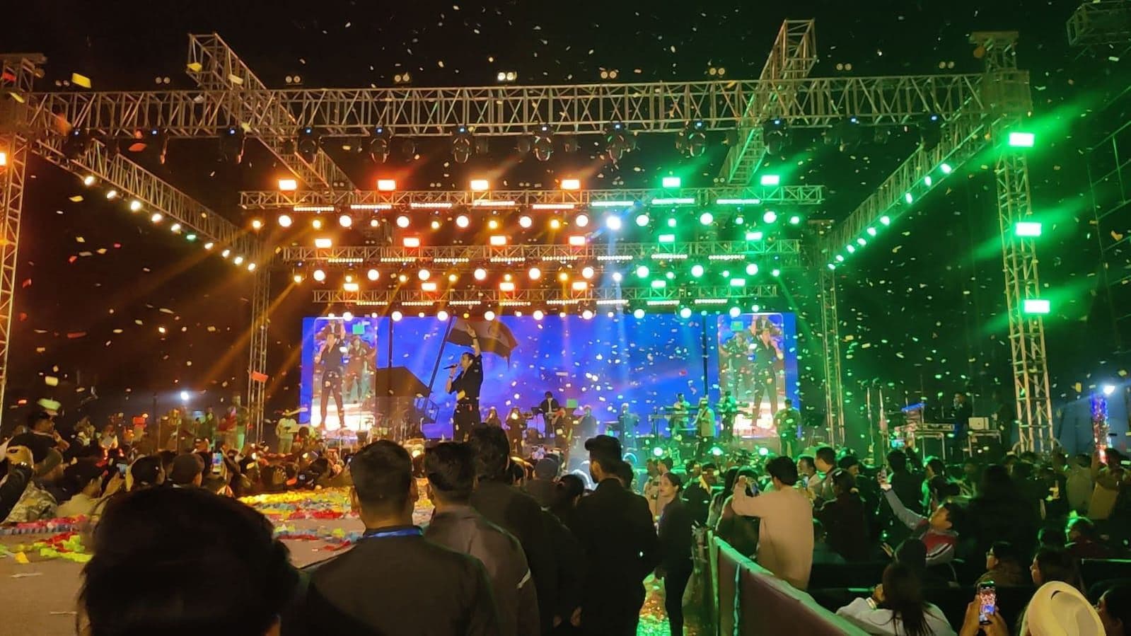 Festival stage with tricolour lighting and confetti over the crowd