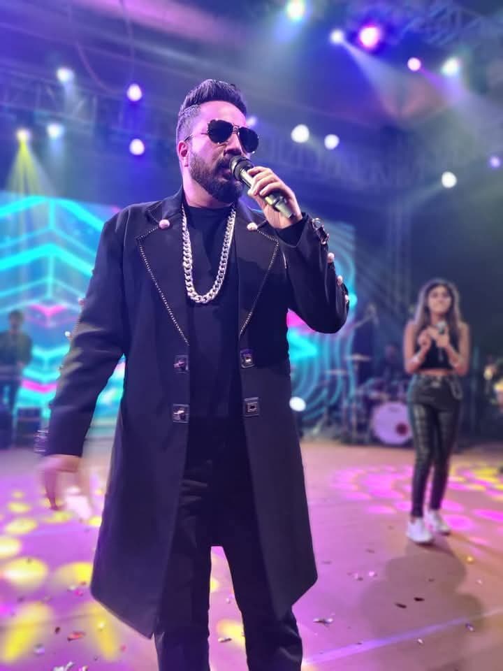 Singer performing live on a colourful stage